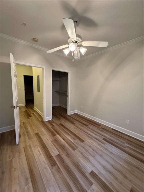 unfurnished bedroom featuring ornamental molding, baseboards, and wood finished floors