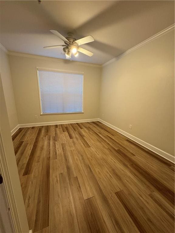 unfurnished room featuring dark wood-style floors, baseboards, and crown molding