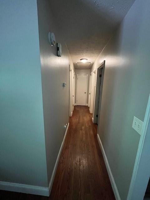 corridor featuring dark hardwood / wood-style flooring and a textured ceiling