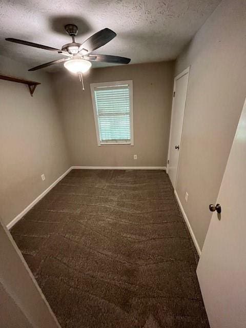 carpeted empty room featuring ceiling fan and a textured ceiling