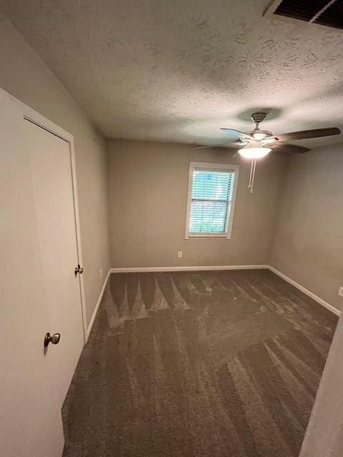 spare room featuring ceiling fan, carpet floors, and a textured ceiling