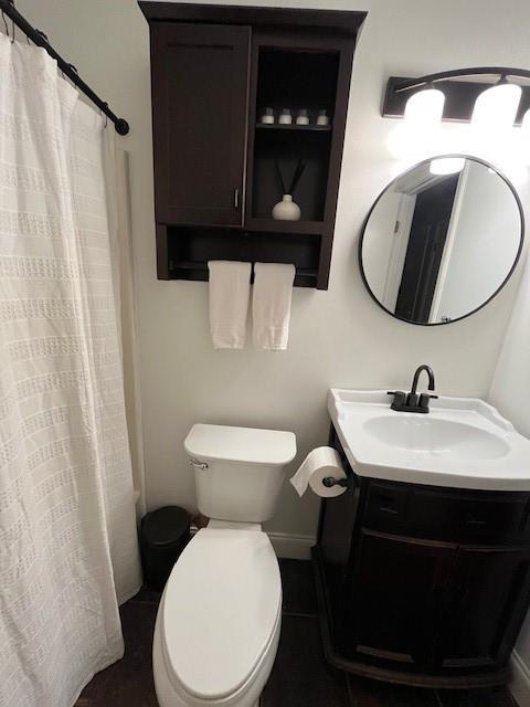 bathroom featuring a shower with curtain, vanity, tile patterned flooring, and toilet