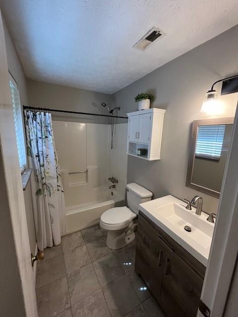 full bathroom with shower / bath combination with curtain, vanity, toilet, and a textured ceiling