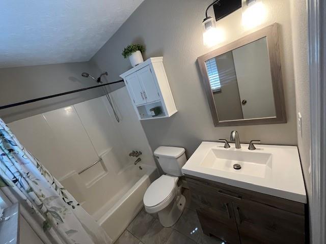 full bathroom with shower / tub combo, vanity, tile patterned flooring, and toilet