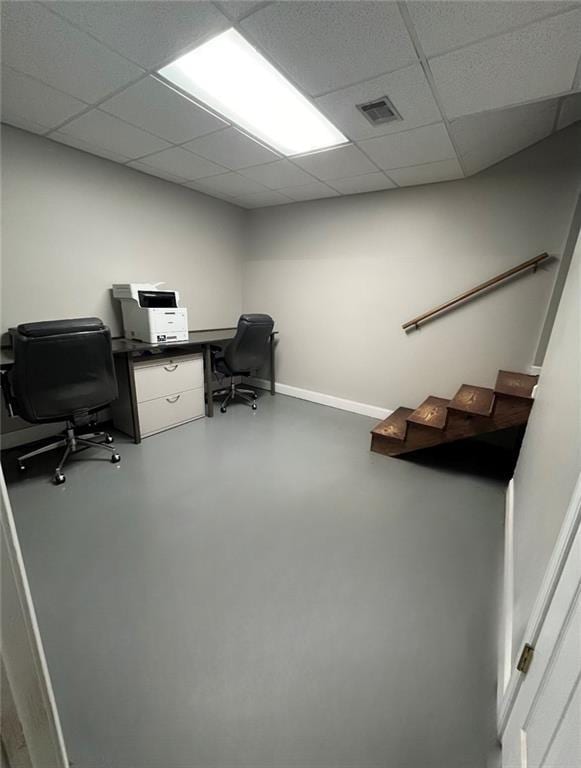 office space with a paneled ceiling and concrete floors