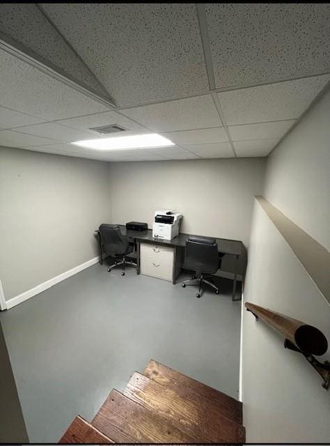 office area with a drop ceiling and concrete flooring