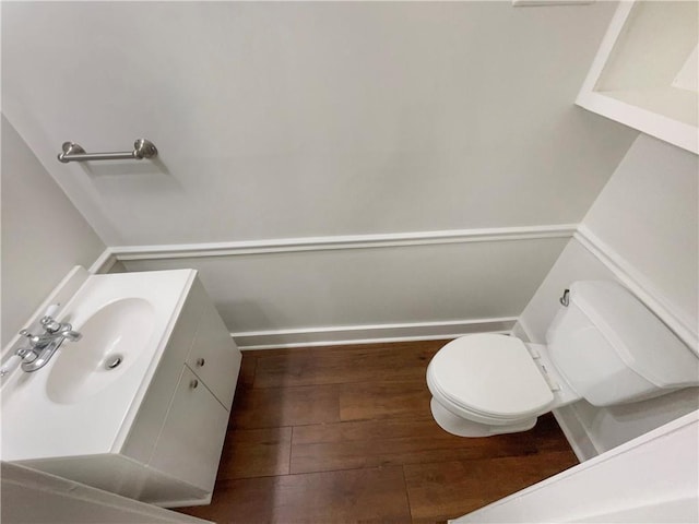 bathroom with wood-type flooring, vanity, and toilet