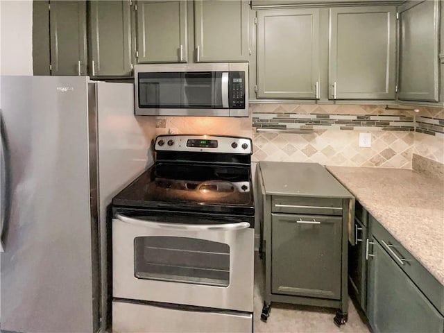 kitchen with decorative backsplash, stainless steel appliances, and green cabinetry