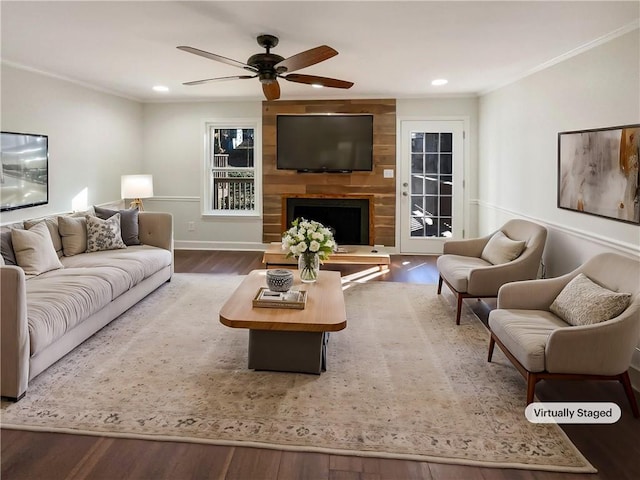 living room with a fireplace, crown molding, wood-type flooring, and ceiling fan