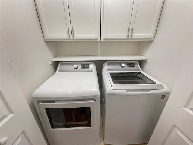 washroom featuring cabinets and washer and dryer