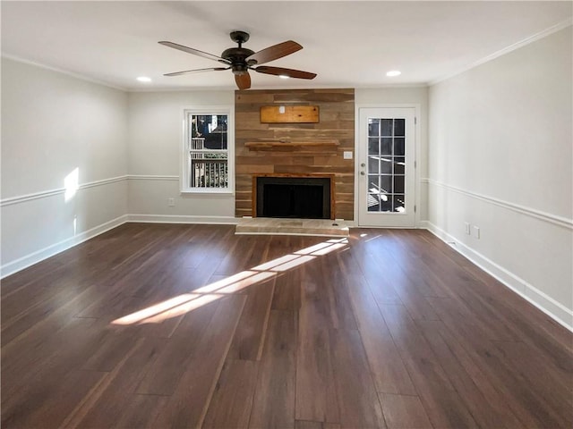 unfurnished living room featuring a large fireplace, ornamental molding, dark hardwood / wood-style floors, and ceiling fan