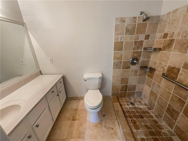 bathroom with vanity, toilet, and a tile shower