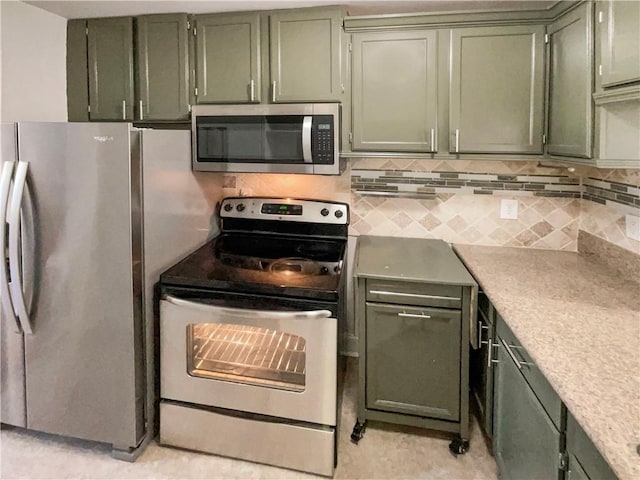 kitchen with decorative backsplash, green cabinetry, and appliances with stainless steel finishes