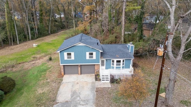 view of front of home featuring covered porch, a garage, and a front lawn