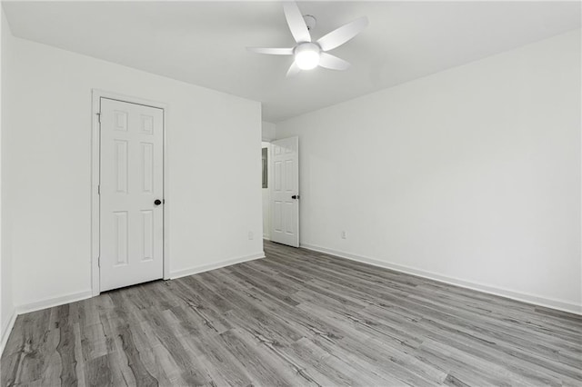 unfurnished bedroom featuring ceiling fan, a closet, and light wood-type flooring