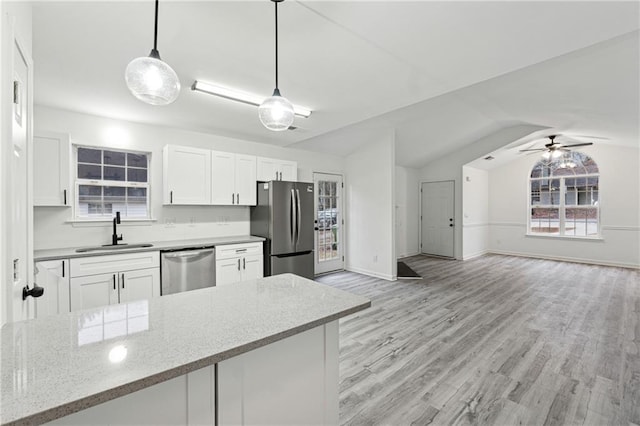 kitchen featuring stainless steel appliances, sink, hanging light fixtures, and white cabinets