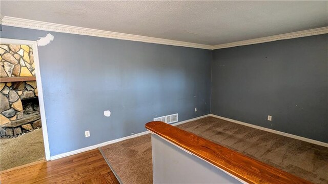 unfurnished room with a fireplace, wood-type flooring, and ornamental molding