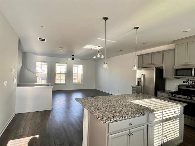 kitchen featuring a center island, appliances with stainless steel finishes, dark hardwood / wood-style floors, ceiling fan, and decorative backsplash