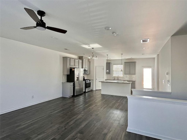 unfurnished living room featuring sink, dark hardwood / wood-style floors, and ceiling fan