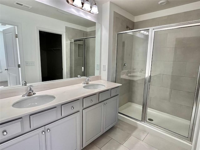 bathroom featuring vanity, tile patterned floors, and walk in shower