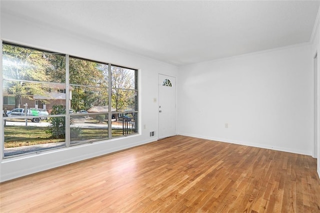 spare room with baseboards, visible vents, and light wood finished floors