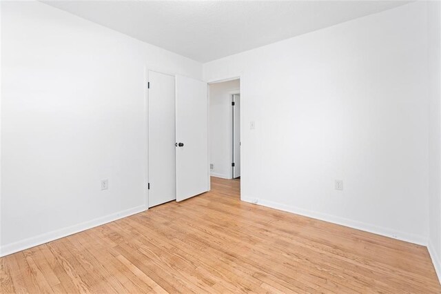 unfurnished room with light wood-style flooring and baseboards