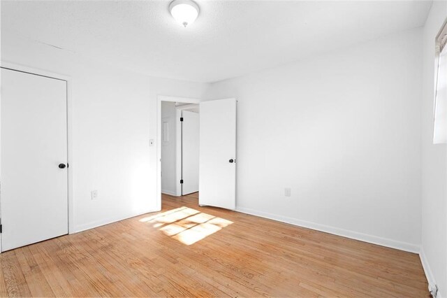 unfurnished bedroom featuring baseboards and wood finished floors