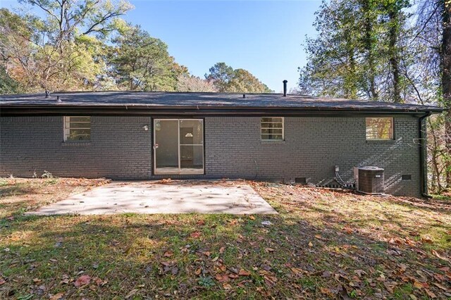 back of house featuring crawl space, a patio, cooling unit, and brick siding