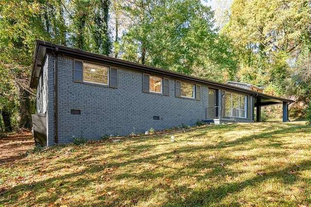 view of front of property featuring brick siding, crawl space, and a front yard