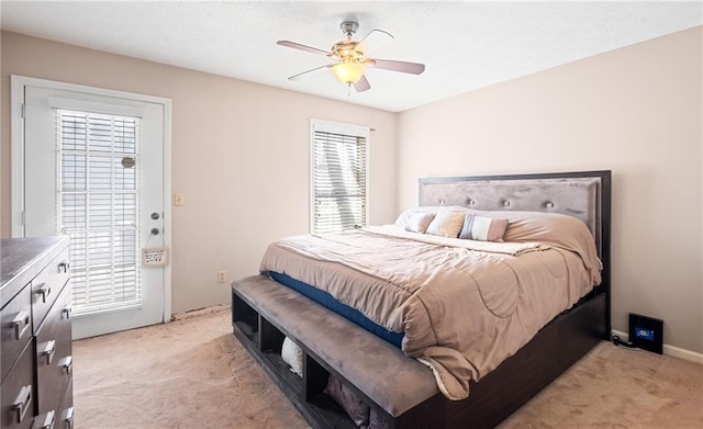 bedroom featuring light carpet and a ceiling fan