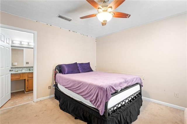 bedroom featuring visible vents, light carpet, baseboards, and connected bathroom