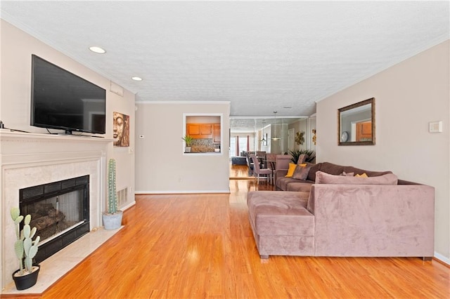 living room featuring wood finished floors, a fireplace, and ornamental molding