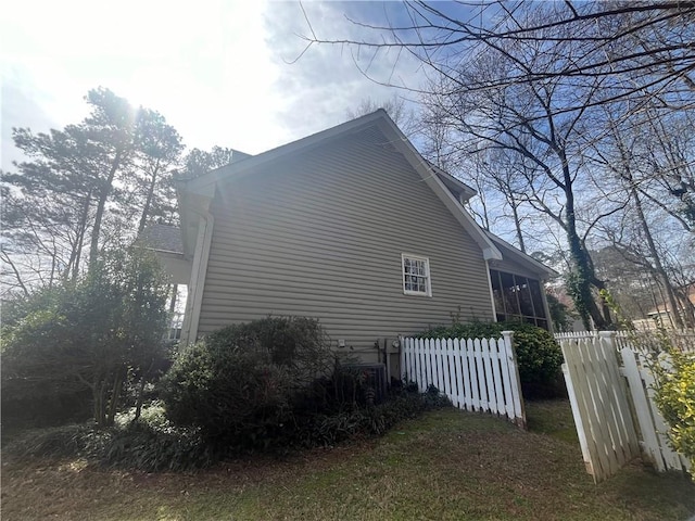 view of side of property featuring a sunroom and fence