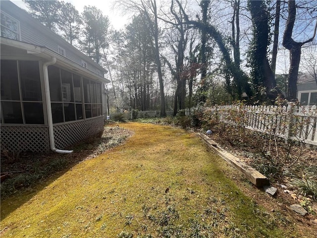 view of yard with fence and a sunroom