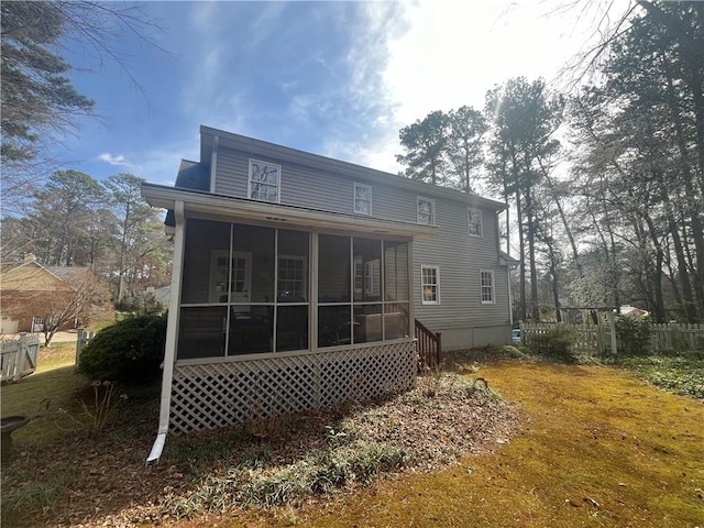 back of property featuring fence and a sunroom