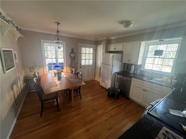 dining space featuring dark wood-style floors, baseboards, crown molding, and a wealth of natural light