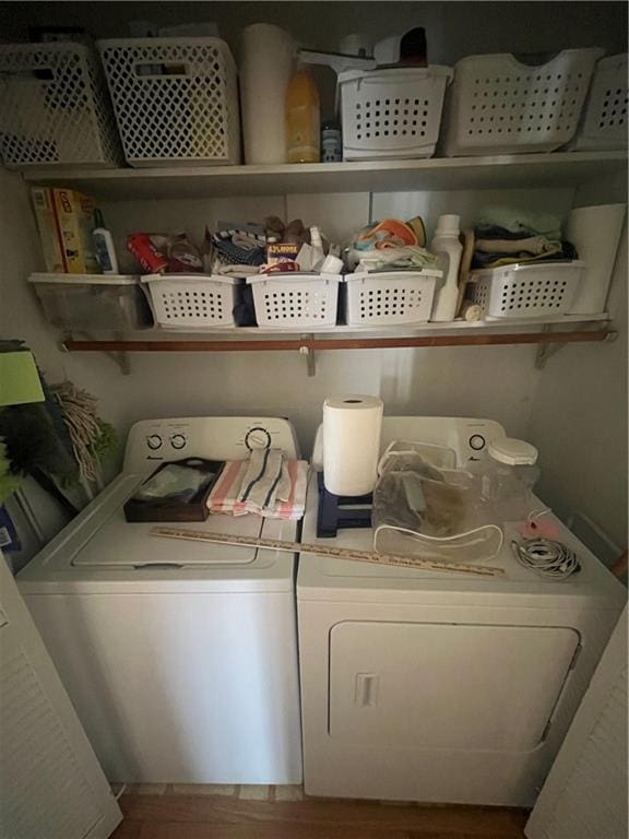 laundry area with washer and dryer, wood finished floors, and laundry area