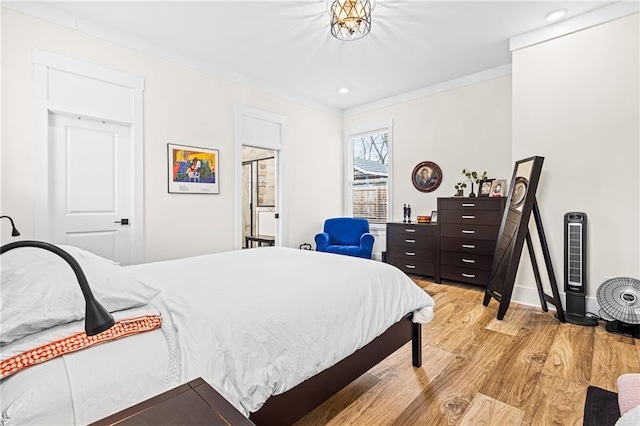 bedroom with light hardwood / wood-style floors and ornamental molding