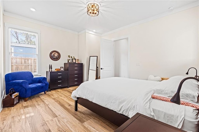 bedroom with light hardwood / wood-style flooring and crown molding