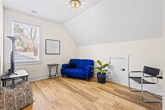 living area with light hardwood / wood-style flooring and lofted ceiling