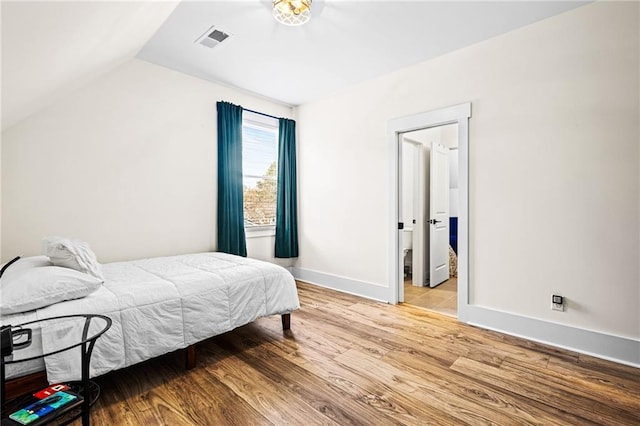 bedroom featuring light wood-type flooring and vaulted ceiling