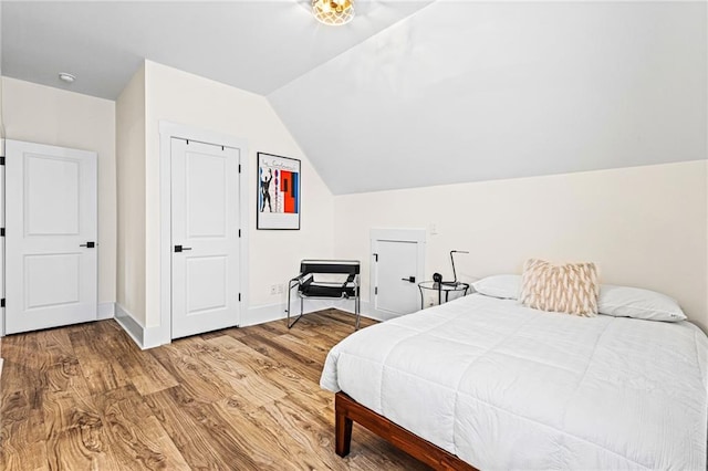 bedroom featuring vaulted ceiling and hardwood / wood-style floors