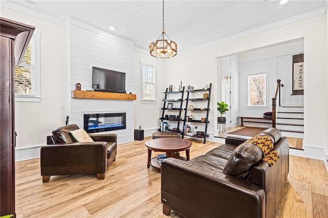 living room featuring ornamental molding, light hardwood / wood-style floors, and a fireplace