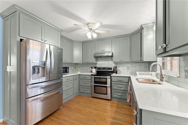 4010 Catawba Rdg, Gainesville, GA 30506 - kitchen featuring appliances with stainless steel finishes, tasteful backsplash, gray cabinetry, light hardwood / wood-style floors, and sink