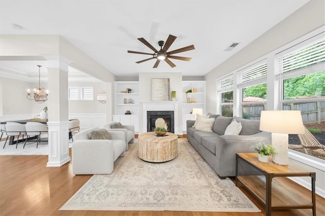 3607 Archgate Ct, Alpharetta, GA 30004 - living area featuring a chandelier, wood finished floors, a high end fireplace, built in features, and ceiling fan