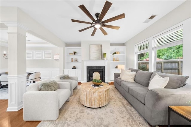 3607 Archgate Ct, Alpharetta, GA 30004 - living room with decorative columns, wood finished floors, a ceiling fan, a premium fireplace, and wainscoting