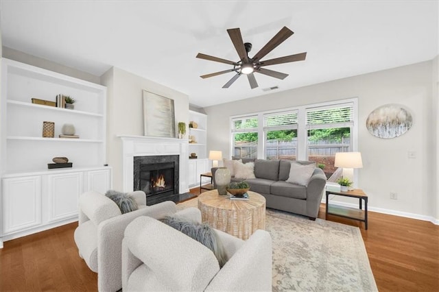 3607 Archgate Ct, Alpharetta, GA 30004 - living area featuring a fireplace, ceiling fan, wood finished floors, baseboards, and built in features