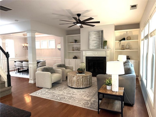 3607 Archgate Ct, Alpharetta, GA 30004 - living area with decorative columns, built in shelves, a fireplace, dark wood-style floors, and wainscoting
