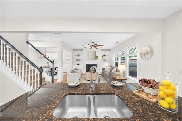 3607 Archgate Ct, Alpharetta, GA 30004 - kitchen with a sink, a ceiling fan, dark stone countertops, a fireplace, and built in features