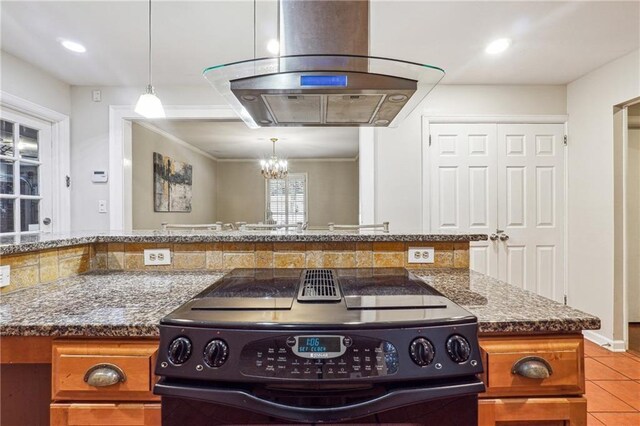 kitchen with island exhaust hood, pendant lighting, electric range, light tile patterned floors, and dark stone countertops